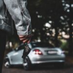 a person holding a car key next to a silver car