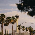 a tall tower towering over a city next to palm trees