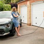A woman washing a car in a driveway