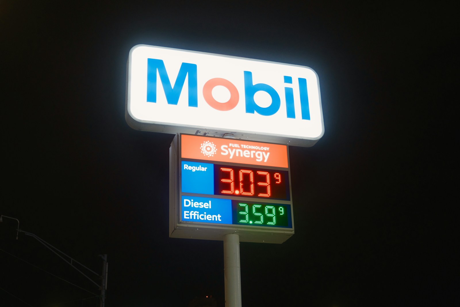 Mobil gas station sign with fuel prices at night